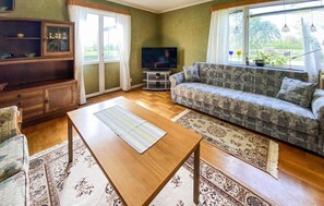 A living room with a sofa, a wooden coffee table, a television, and a cabinet. - 3 bedroom nice home in Borgholm (Borgholm)