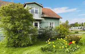 A two-story house with a balcony, surrounded by greenery and flowers. - 3 bedroom nice home in Borgholm (Borgholm)
