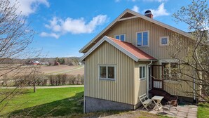 A two-story house with a sloped roof and a small porch with outdoor seating. - 3 bedroom nice apartment in Fjällbacka (Fjällbacka)