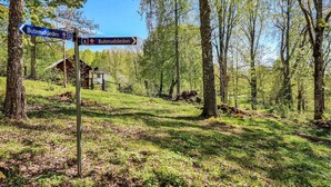 A signpost with directions to Buterudsleden, surrounded by a forested area with a small building in the background. - 3 bedroom lovely home in Håverud (Håverud)