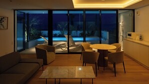Un salon moderne avec un mur en verre, une piscine et un coin repas.