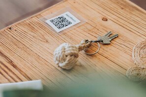 Une surface en bois avec un code QR, un porte-clés et une balle en corde.