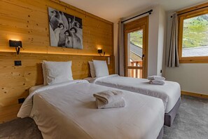 Ein Hotelzimmer mit zwei Betten, Holzvertäfelung, einem Gemälde und einem Fenster mit Blick.
