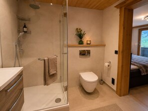 Ein modernes Badezimmer mit Glasdusche, Toilette und Waschbecken.