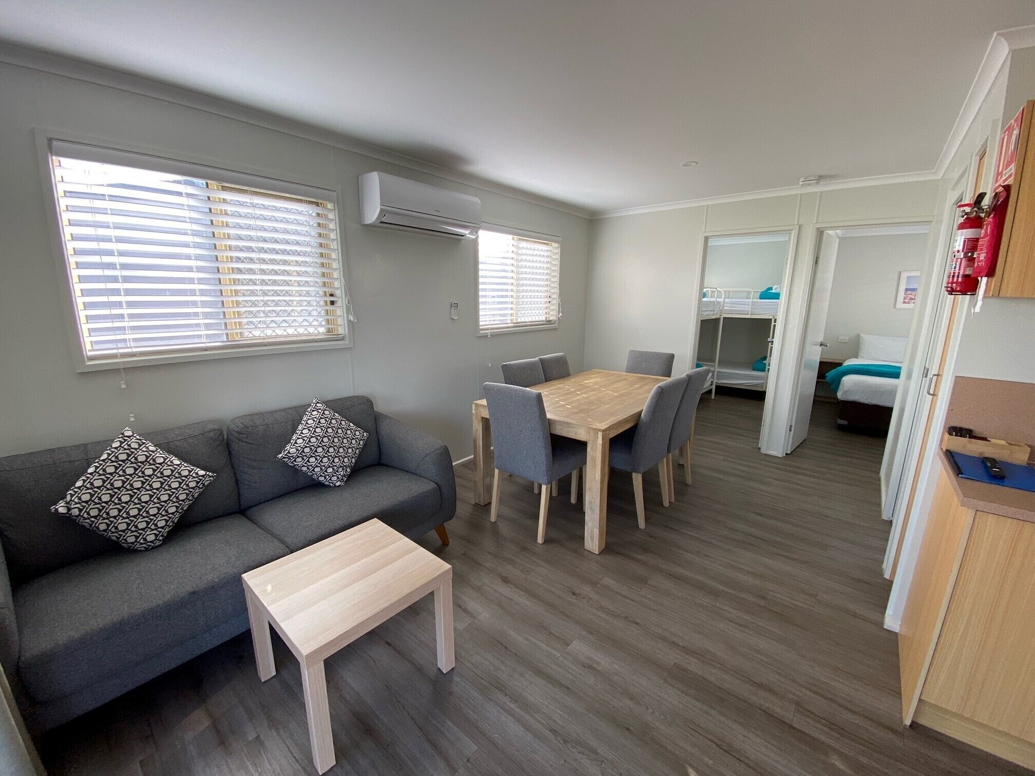 Un espacio habitable compacto con sofá, una mesa de comedor y una kitchenette.