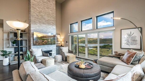 A spacious living room with a fireplace, comfortable seating, and large windows offering a scenic view. - Spacious Retreat | 5 King Beds | Hot Tub & Views (Deer Valley)
