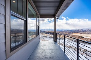 Ein Balkon mit Blick auf Berge und einen klaren Himmel.