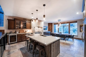 A spacious kitchen with a large island, wooden cabinets, and a stone backsplash. - Experience luxury in this 3BR, 3.5BA loft in Deer Valley, Park City, with stunning mountain views. (Park City)