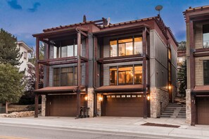 A modern two-story house with a garage, large windows, and a stone foundation. - Experience luxury in this 3BR, 3.5BA loft in Deer Valley, Park City, with stunning mountain views. (Park City)