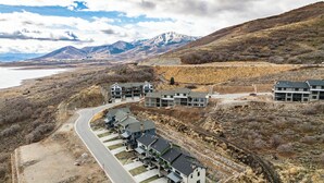 Un barrio residencial con casas modernas, una carretera y montañas al fondo.