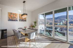 Ein Essbereich mit einem großen Tisch, Stühlen und Kunstwerken an der Wand.