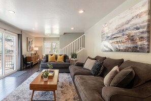 Ein Wohnzimmer mit Sofa, Couchtisch und Kunstwerk an der Wand.