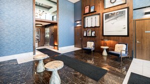 A modern lobby with a marble floor, wooden paneling, and a large framed artwork on the wall. - 1BR in DV East, Steps to Gondola Ski-in/out, Amenities (Park City)