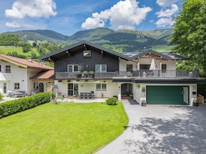 Ein zweistöckiges Haus mit Balkon, Garage und einem gepflegten Rasen.