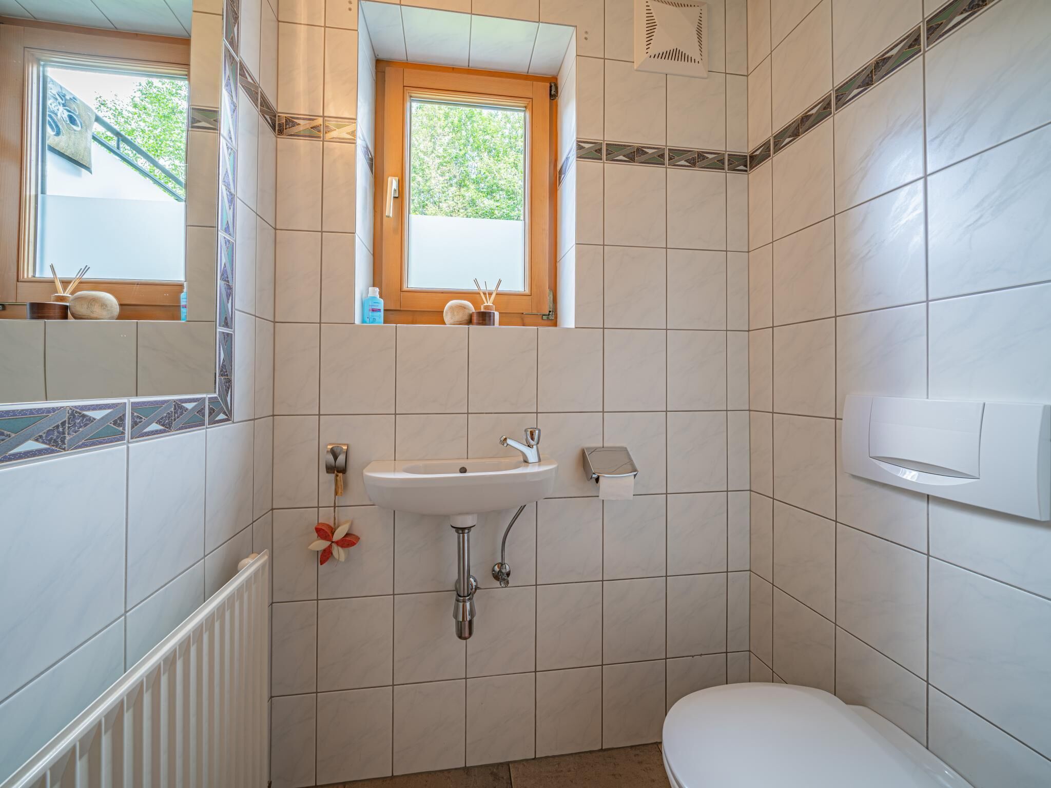 Une salle de bain avec un lavabo, des toilettes et une fenêtre.