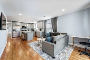 Ein modernes Apartment mit Küche, Wohnbereich und einem kleinen Esstisch.