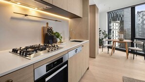 A modern kitchen with a gas stove, dishwasher, and wooden cabinets.