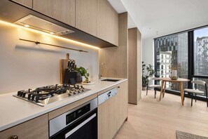 Eine moderne Küche mit Gasherd, Geschirrspüler und Holzschränken.