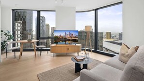 A modern living room with a city view, a dining area, and a large window.