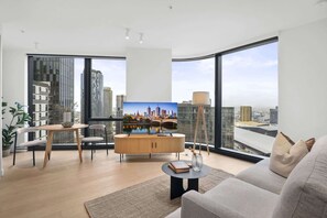 Ein modernes Wohnzimmer mit Blick auf die Stadt, einer Essecke und einem großen Fenster.