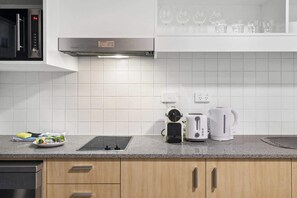 Eine moderne Küche mit Einbau-Mikrowelle, Wasserkocher, Toaster und Kaffeemaschine auf der Arbeitsfläche.