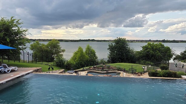 Ein Schwimmbad mit Blick auf einen See und einen bewölkten Himmel.