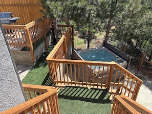 A hot tub surrounded by wooden railings and a wooden deck.