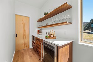 Eine Küche mit Holzböden, einer Arbeitsplatte und Blick ins Freie.