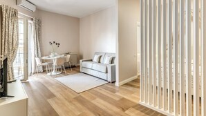 A modern living room with a sofa, dining table, and a TV. - Casa Vostra Vaticano (Rome)