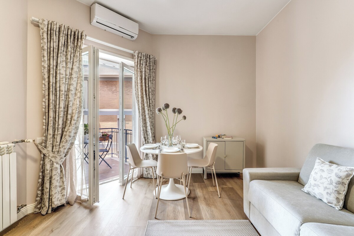 A modern living room with a dining table, chairs, a sofa, and a radiator.