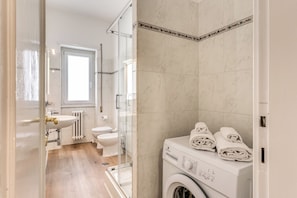 Un baño con lavabo, inodoro y lavadora.