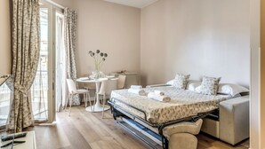 A bedroom with a bed, bedside tables, a desk, and a chair. - Casa Vostra Vaticano (Rome)