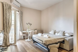 Un dormitorio con cama, mesitas de noche, escritorio y una silla.
