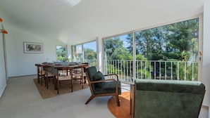 A spacious room with a dining area, a balcony with a view of trees, and a large window. - Villa 5 ch. Mer et Rivière entre Nice & Cannes (Villeneuve-Loubet)