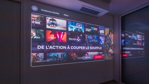 A digital display with movie posters and a promotional message for a streaming service. - Villa 5 ch. Mer et Rivière entre Nice & Cannes (Villeneuve-Loubet)