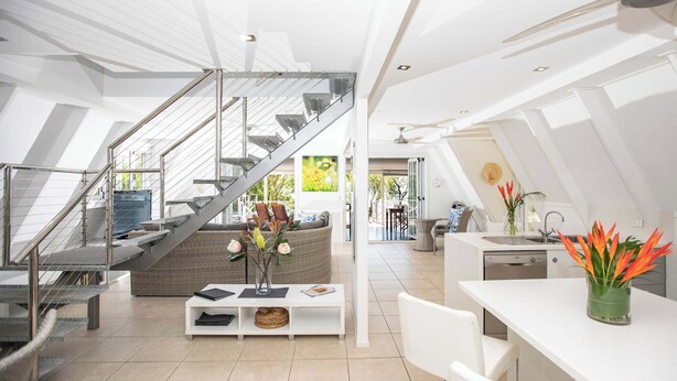 A modern interior with a staircase, a dining area, and a kitchen. - Cottonwood Port Douglas (Oak Beach)