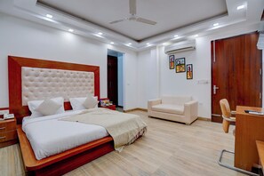Une chambre moderne avec un grand lit, une tête de lit en bois, une table de chevet, un bureau, une chaise et une armoire.