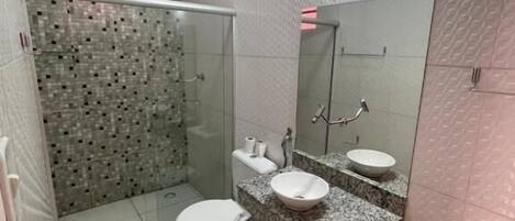 A bathroom with a shower, toilet, and sink.