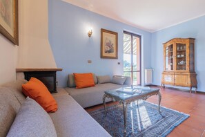 A living room with a sofa, a coffee table, a cabinet, and a fireplace. - CASA ZOLIA MENDIA, Freshness in the evening, family apartment with view. (Renzano)