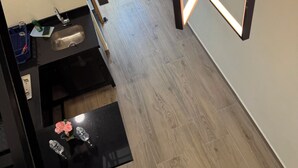 A modern kitchen with a black countertop, a stainless steel sink, and a wooden floor. - Beautiful loft in Chapultepec (Guadalajara)