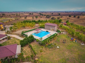 A residential property with a swimming pool, a covered patio, and a playground.