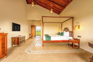 A four-poster bed with a wooden headboard, a bedside table, and a nightstand.