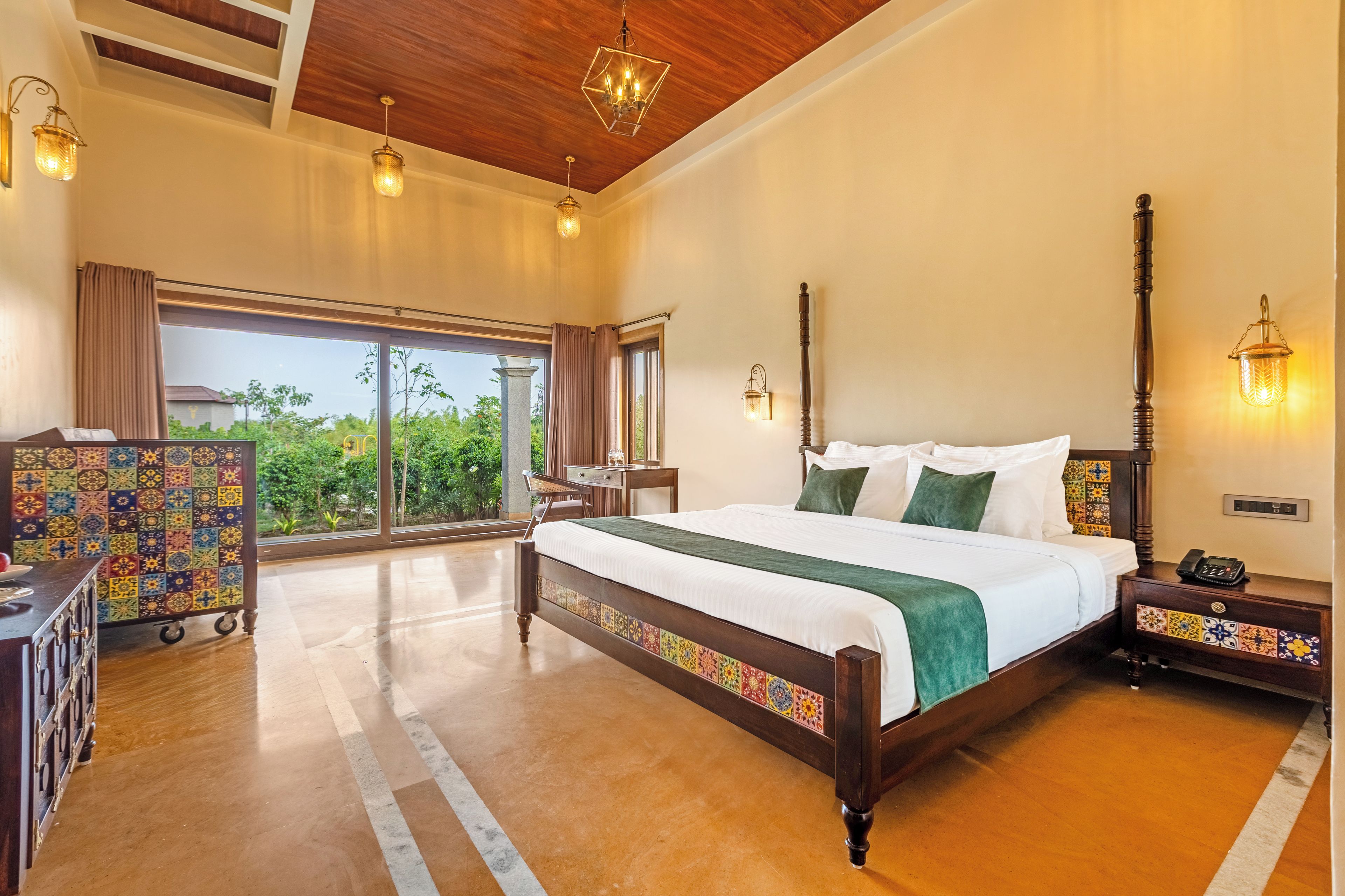 A hotel room with a large bed, a desk, a chair, and a view of the outdoors.
