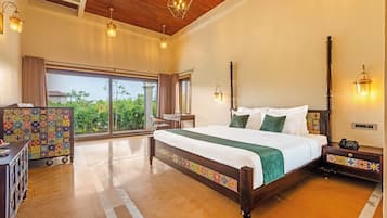A hotel room with a large bed, a desk, a chair, and a view of the outdoors.