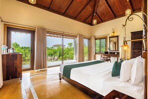 Um quarto espaçoso com uma cama grande, uma escrivaninha e vista para o verde lá fora.