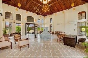 A spacious lobby with a high ceiling, multiple seating areas, and a central decorative fountain. - Sterling Vanyatara Tadoba (Chimur)