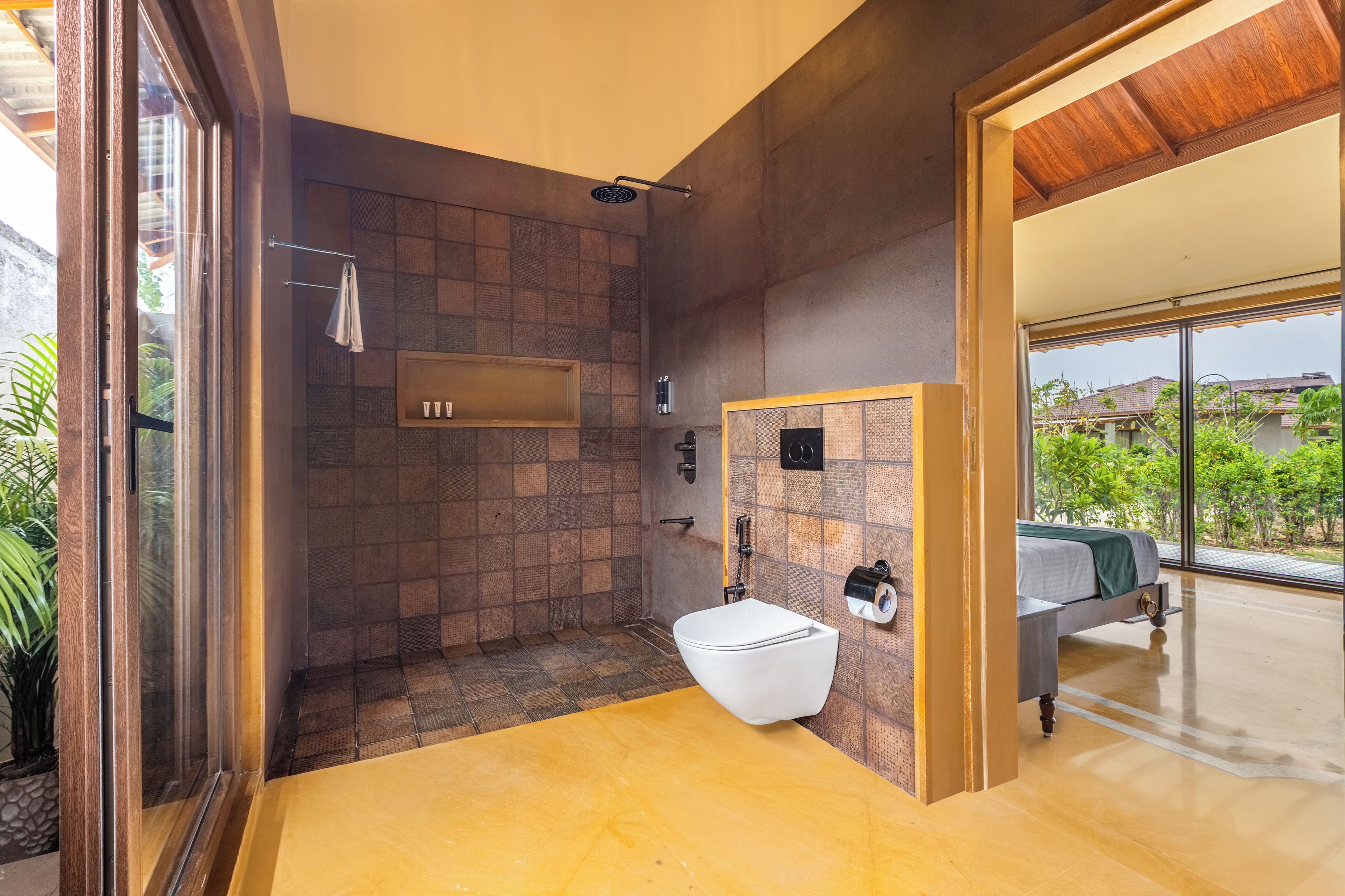 A modern bathroom with a shower, toilet, and sink, featuring a large window and a view of the outdoors.