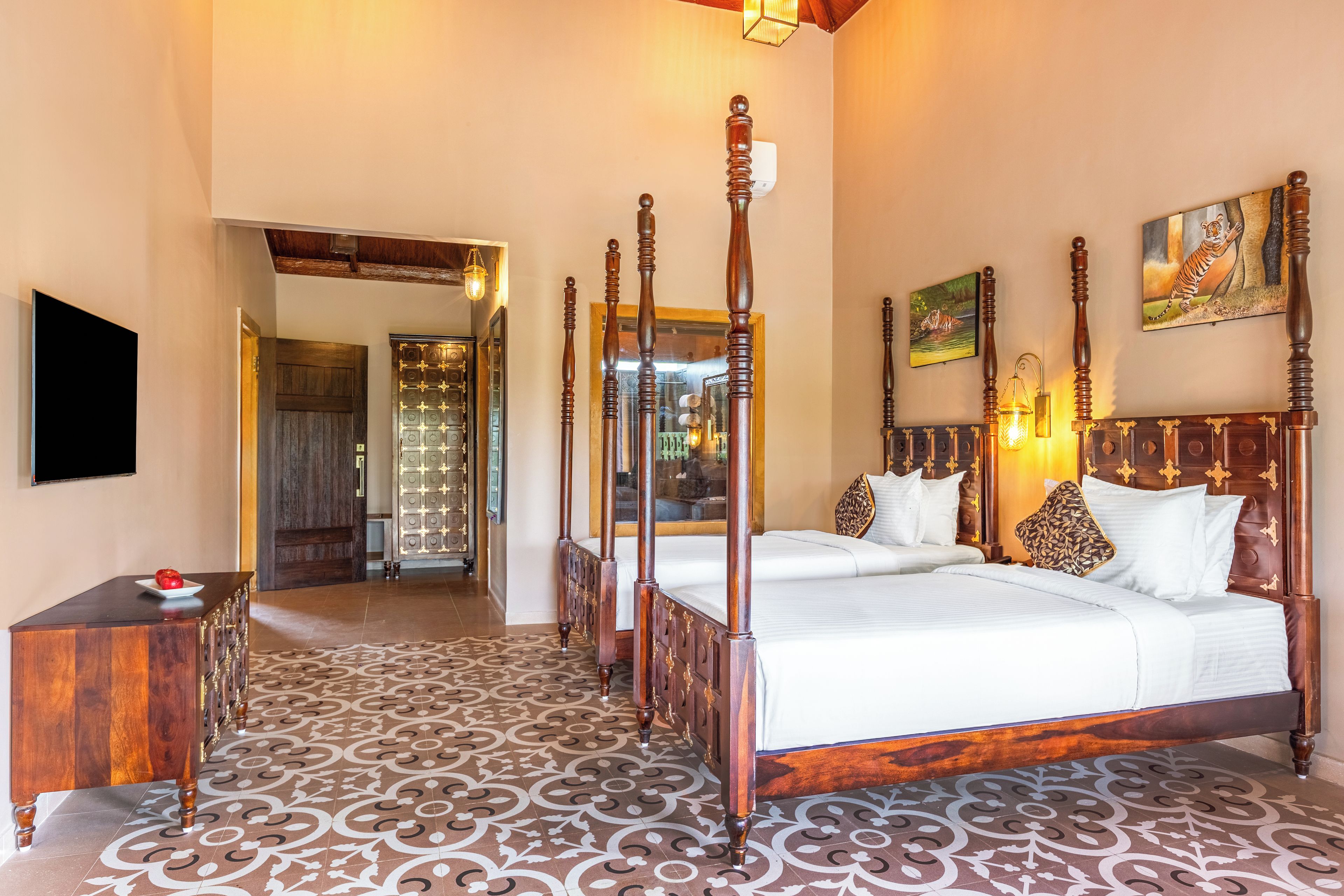 A hotel room with a four-poster bed, a television, and a decorative mirror.