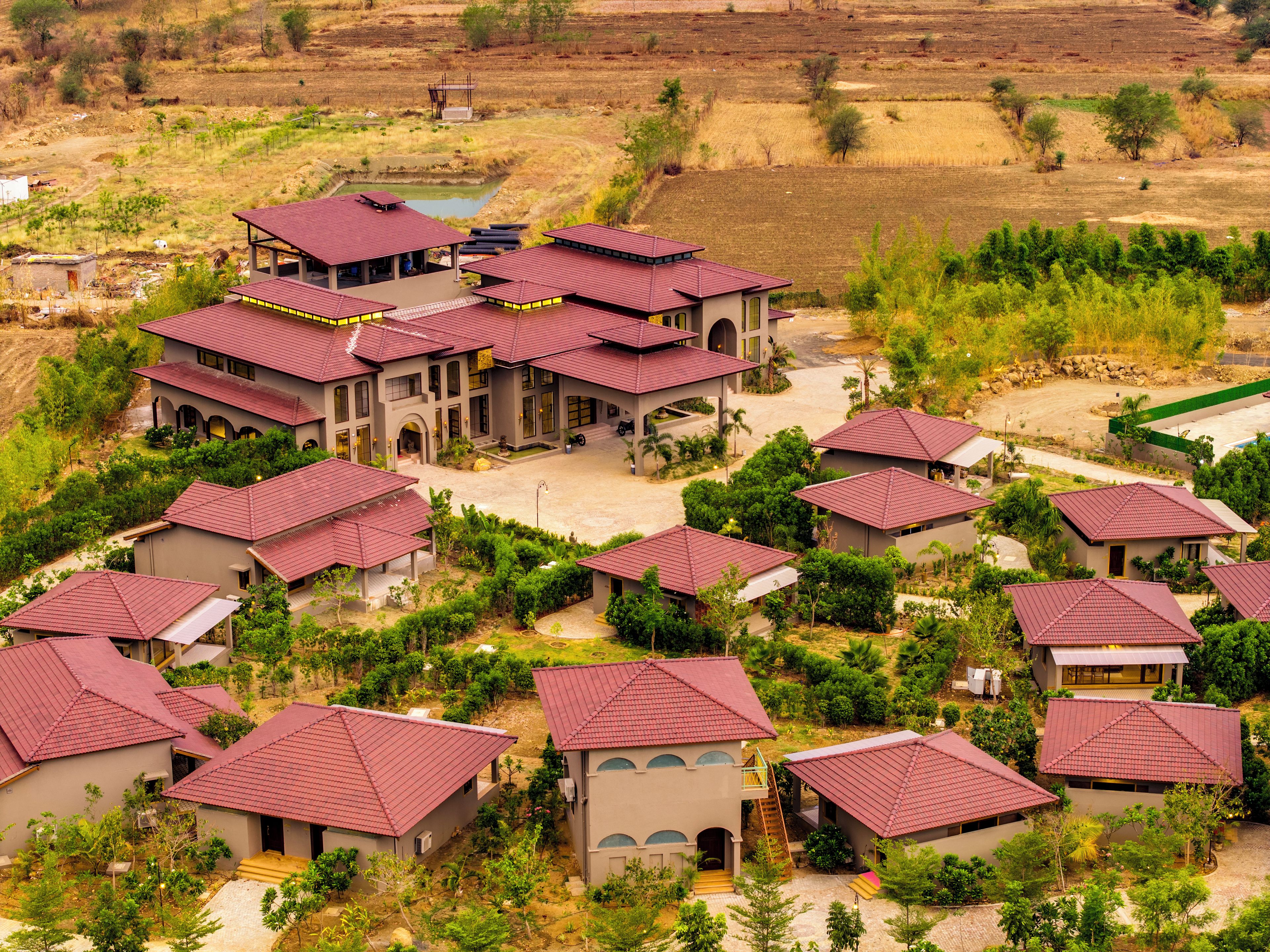 A residential area with multiple houses featuring red roofs and a central building with a large porch.