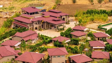 A residential area with multiple houses featuring red roofs and a central building with a large porch.